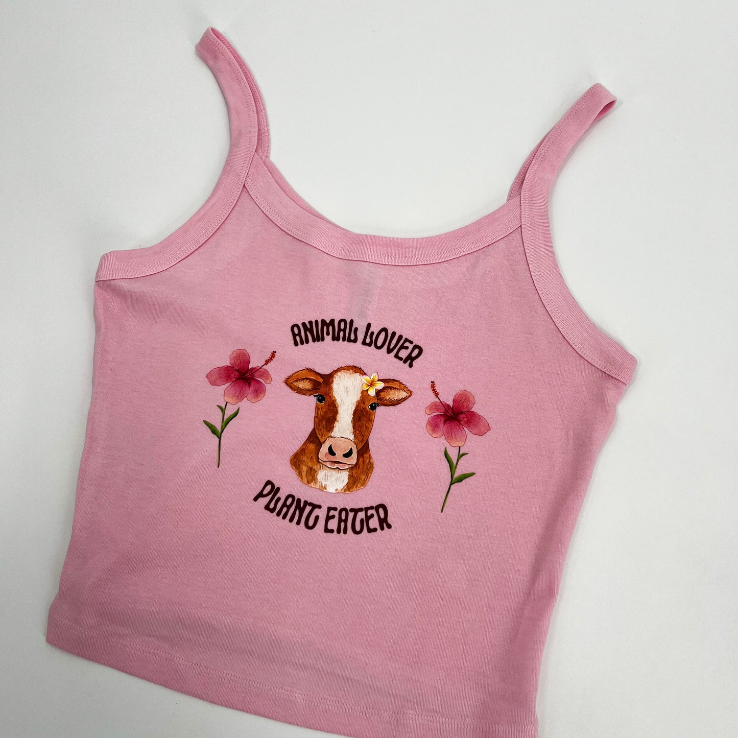 Cute pink and blue crop top featuring vegan activism graphic of a cow with flowers and text animal lover plant eater