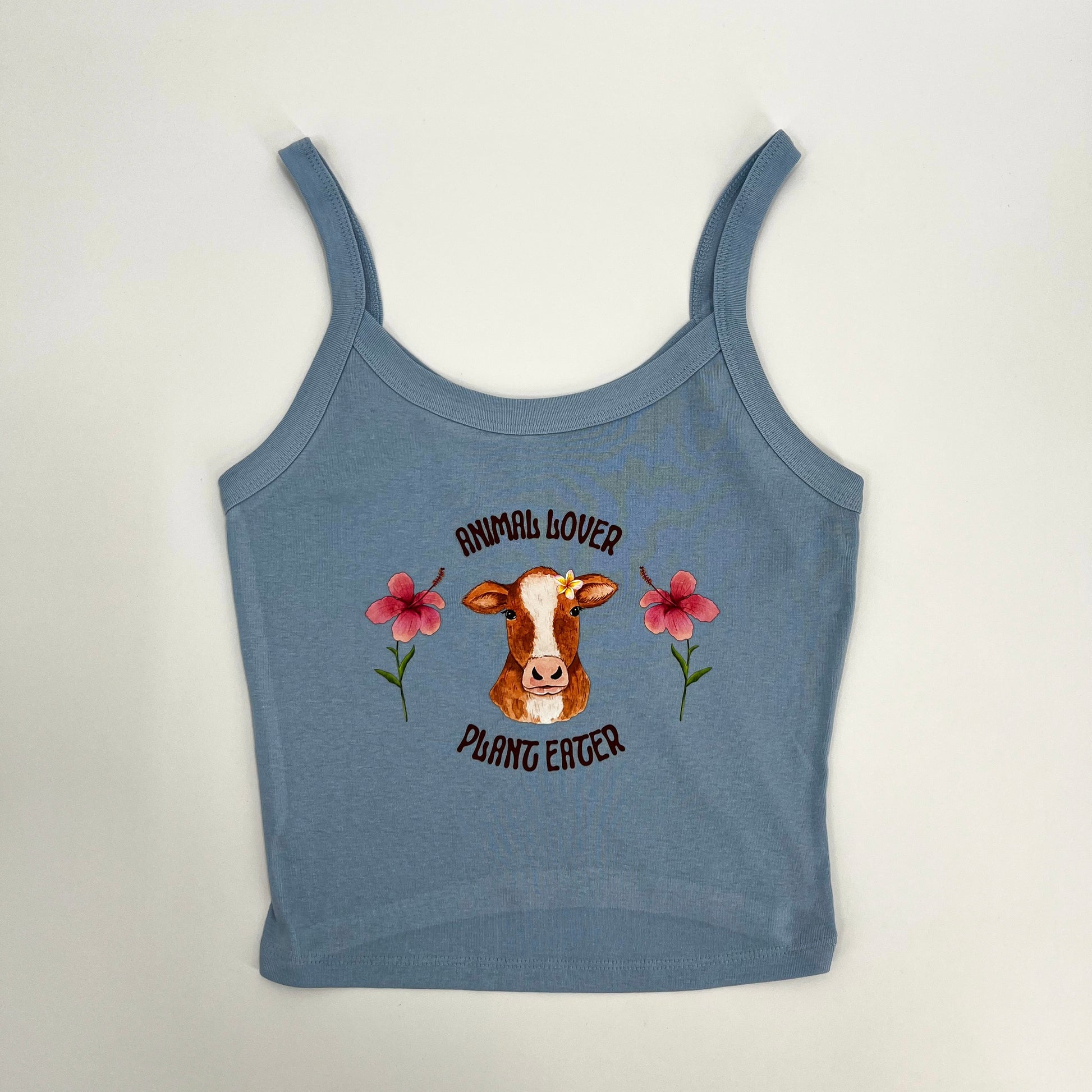 Cute pink and blue crop top featuring vegan activism graphic of a cow with flowers and text animal lover plant eater