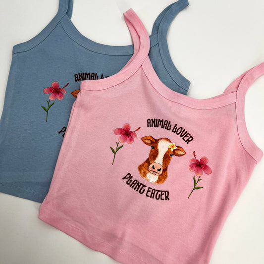 Cute pink and blue crop top featuring vegan activism graphic of a cow with flowers and text animal lover plant eater