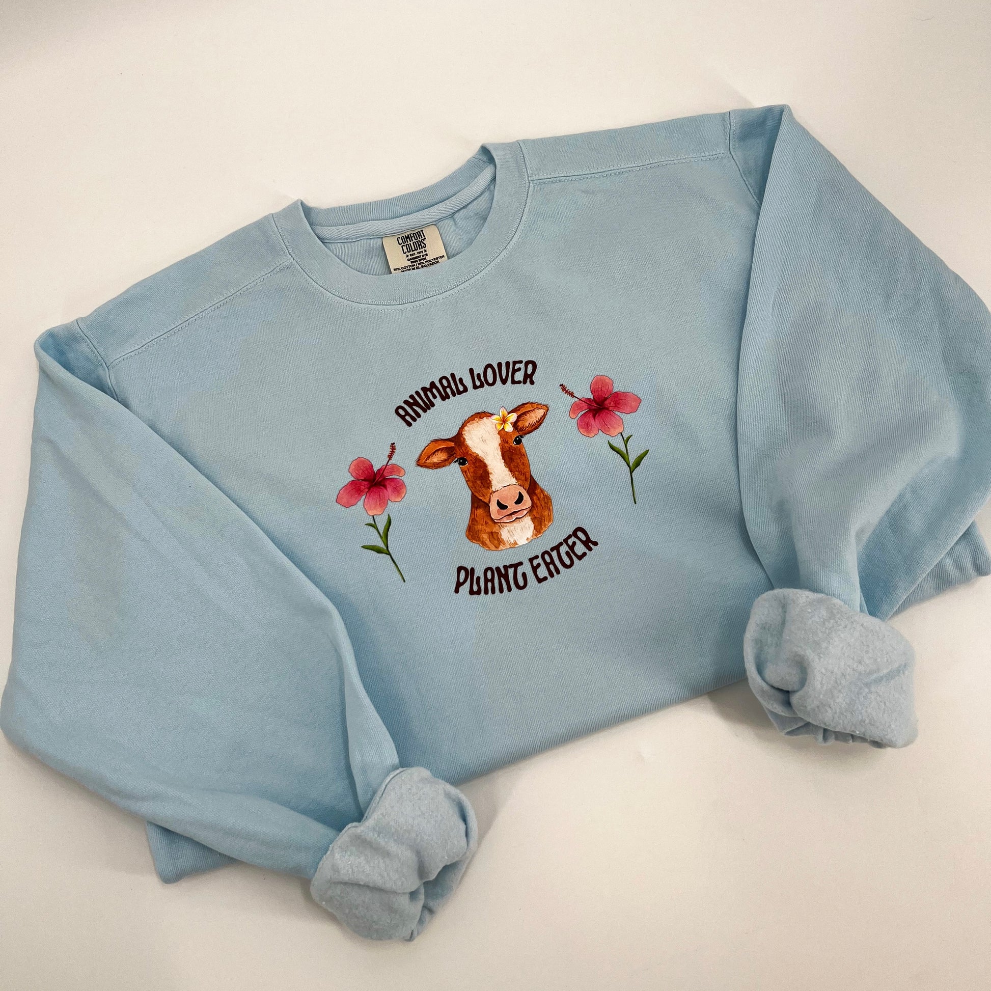 Light blue crewneck sweatshirt with vegan activism graphic Animal Lover Plant Eater