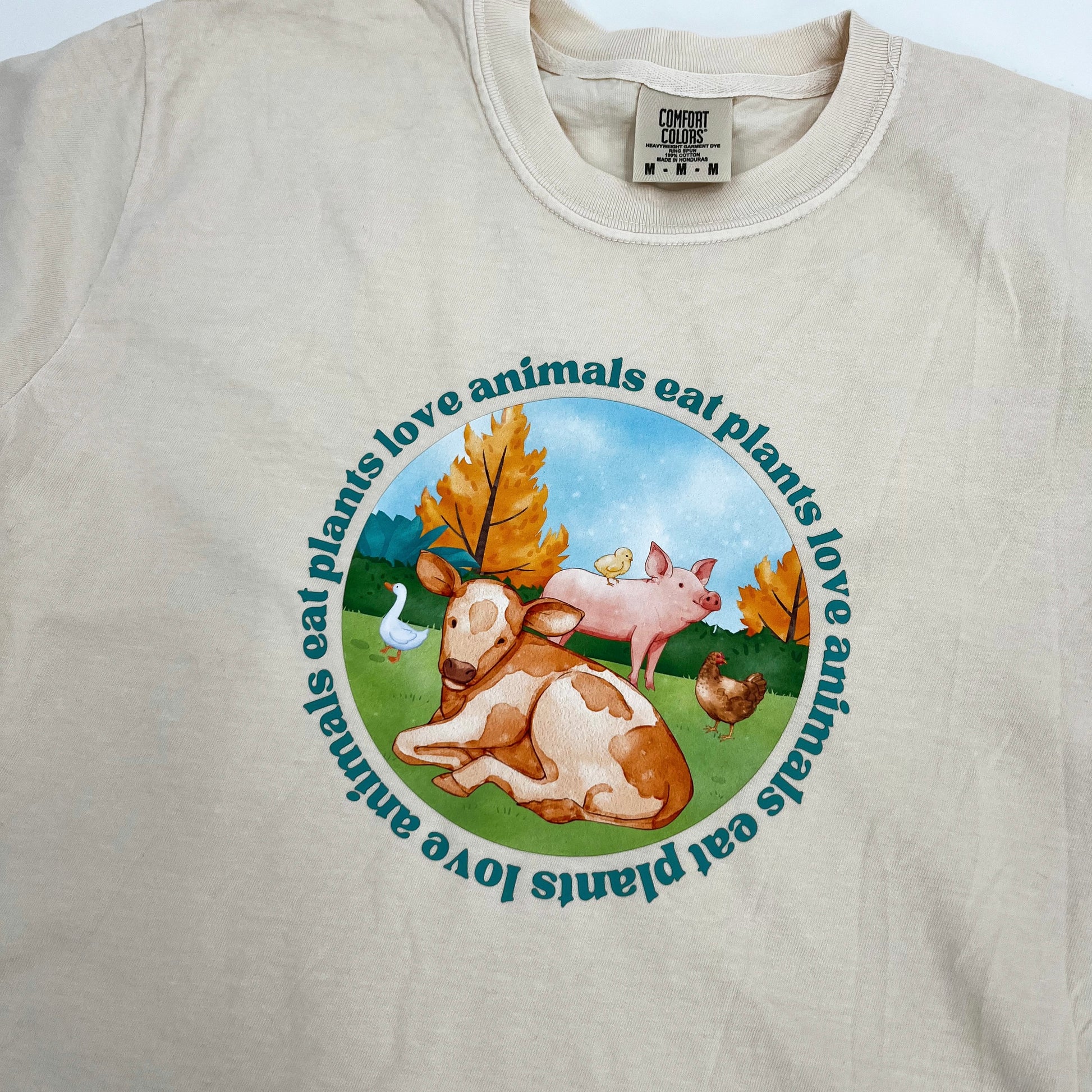 Natural colored vegan activism tee featuring farm animals graphic and text Love Animals Eat Plants