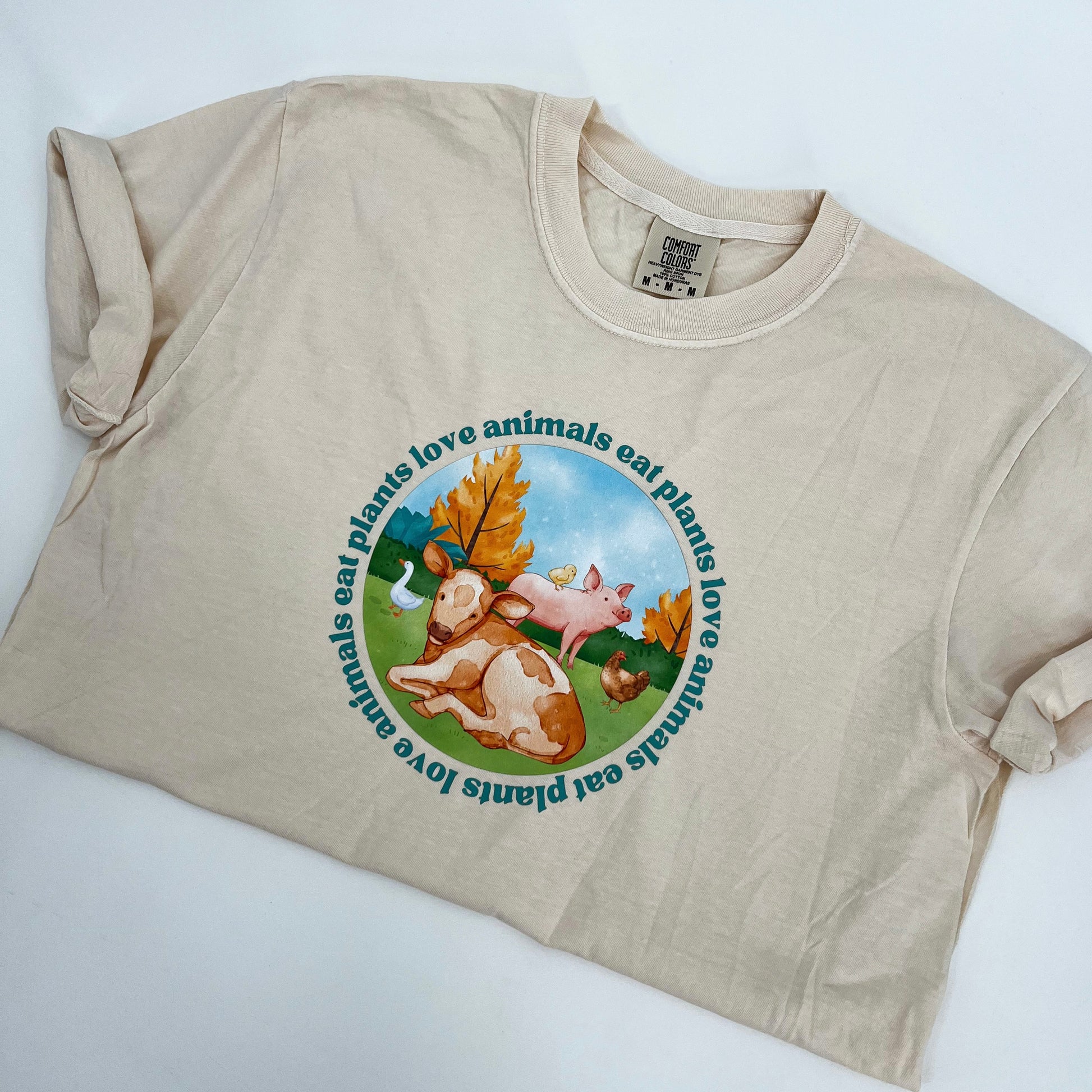 Natural colored vegan activism tee featuring farm animals graphic and text Love Animals Eat Plants