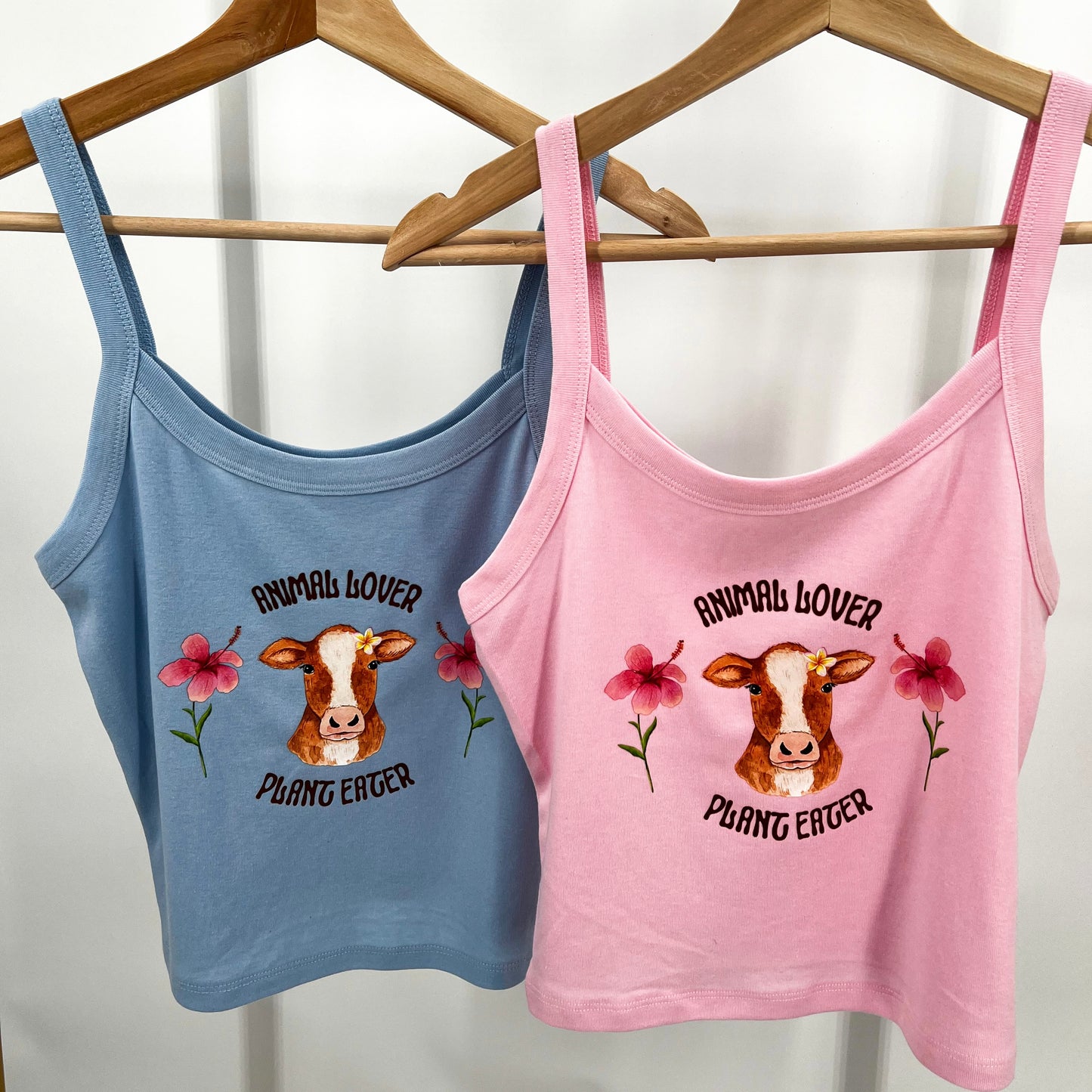 Cute pink and blue crop top featuring vegan activism graphic of a cow with flowers and text animal lover plant eater