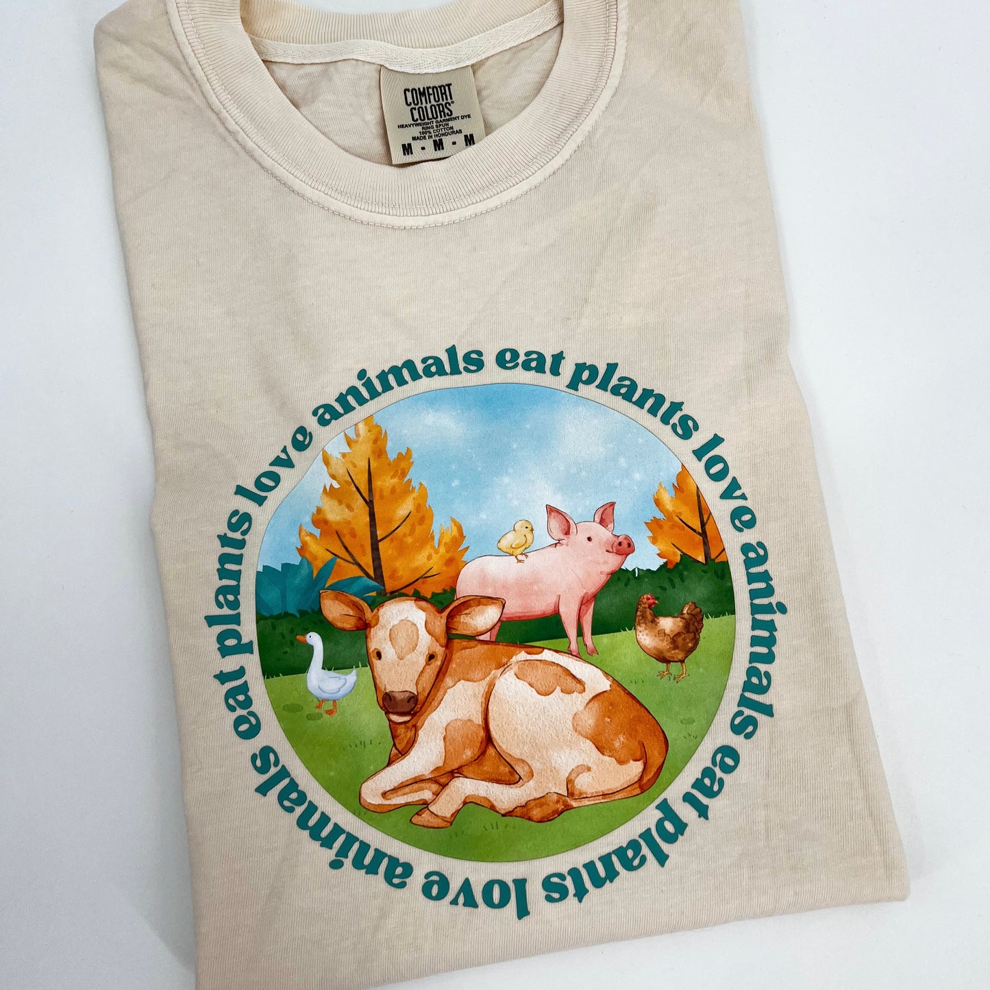 Natural colored vegan activism tee featuring farm animals graphic and text Love Animals Eat Plants