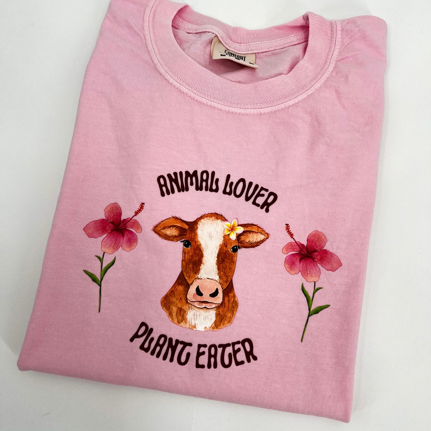 Pink T-shirt featuring vegan activism graphic Animal Lover Plant Eater