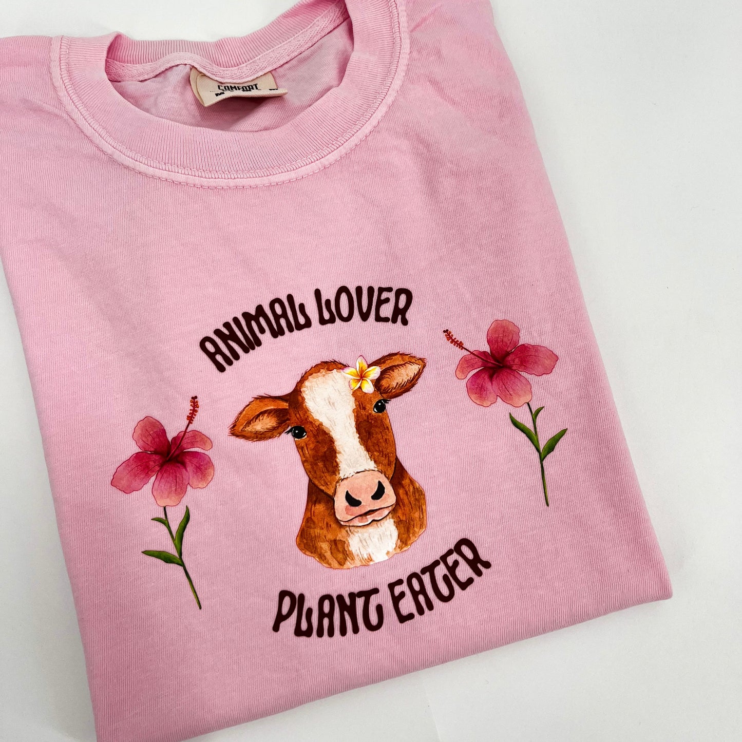 Pink T-shirt featuring vegan activism graphic Animal Lover Plant Eater