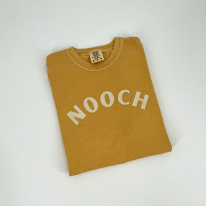 Mustard colored vegan activism t-shirt featuring "Nooch" graphic