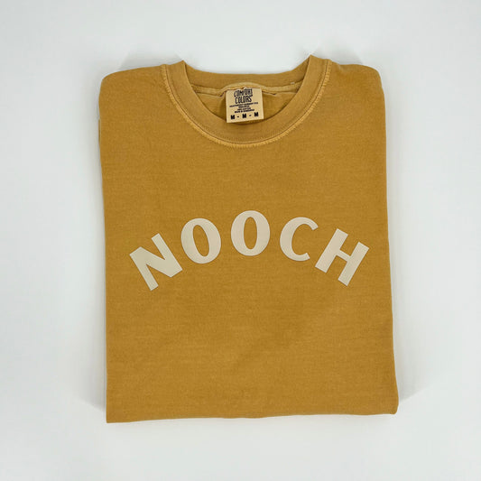 Mustard colored vegan activism t-shirt featuring "Nooch" graphic