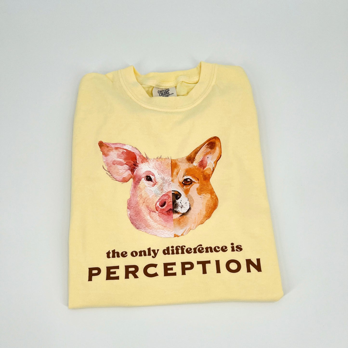 Yellow vegan activism t-shirt featuring "the only difference is perception" graphic