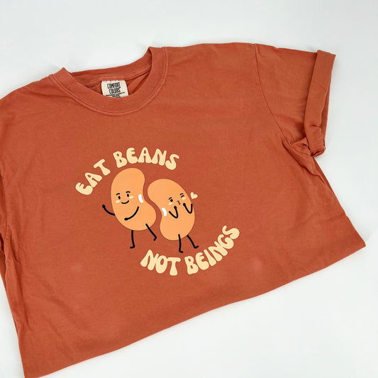 Terracotta colored vegan activism shirt featuring "Eat Beans Not Beings" graphic