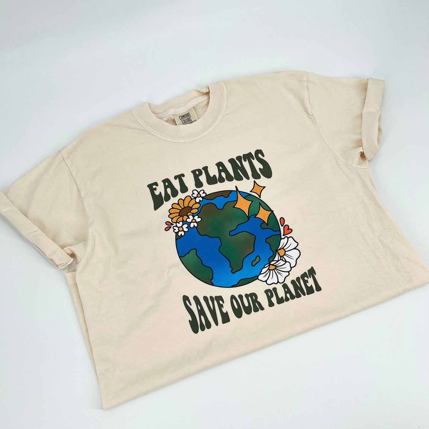 Ivory colored vegan activism t-shirt featuring "Eat Plants, Save Our Planet" graphic