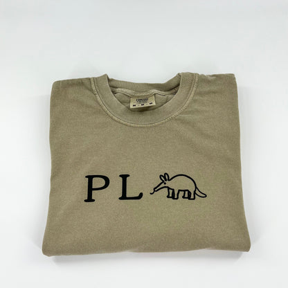 Punny P L Anteater vegan activism design in black on a khaki colored cotton shirt